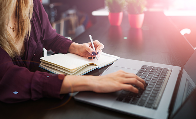 Woman taking notes during an online meeting